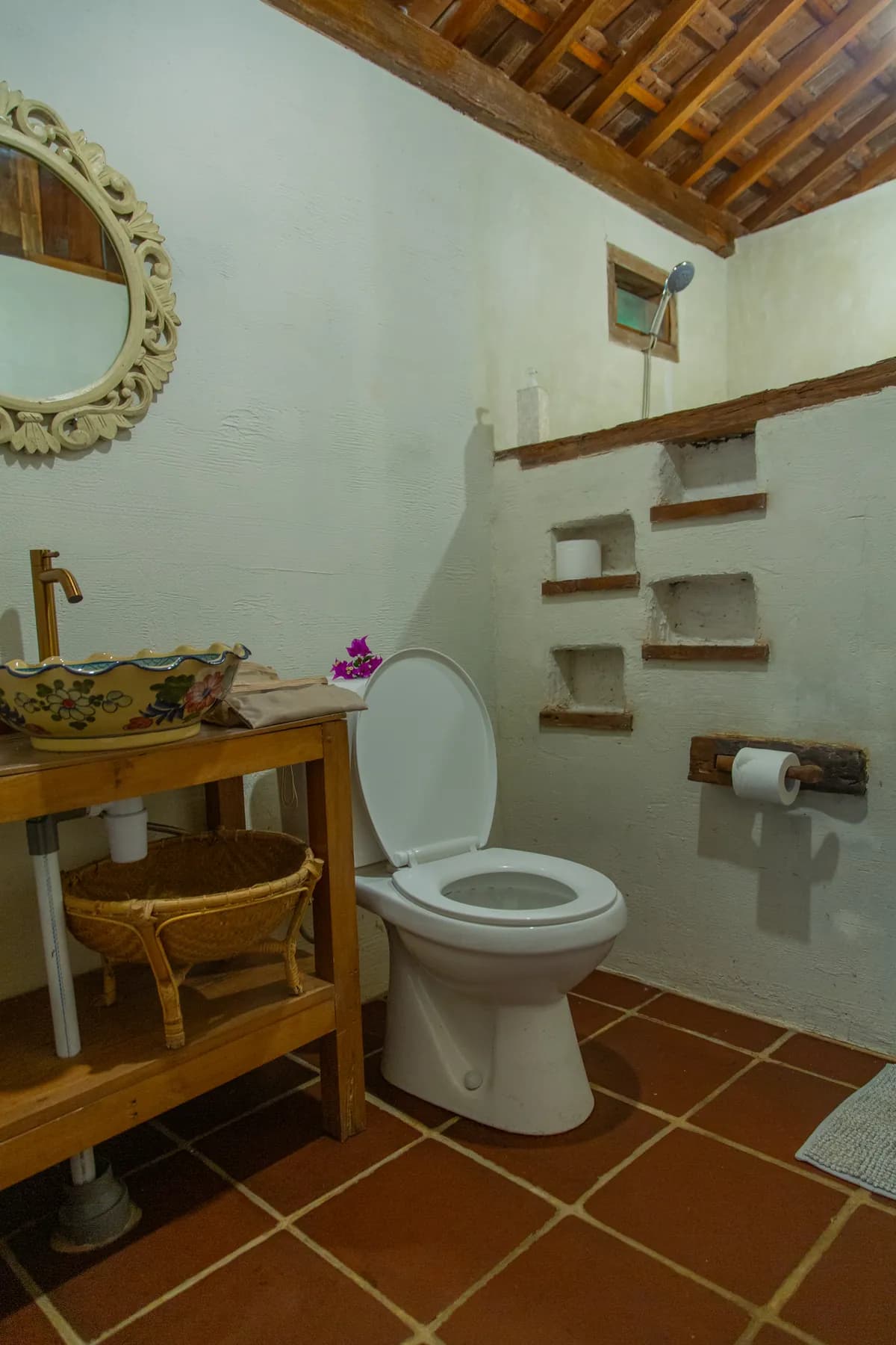 A hand-painted basin under a carved mirror