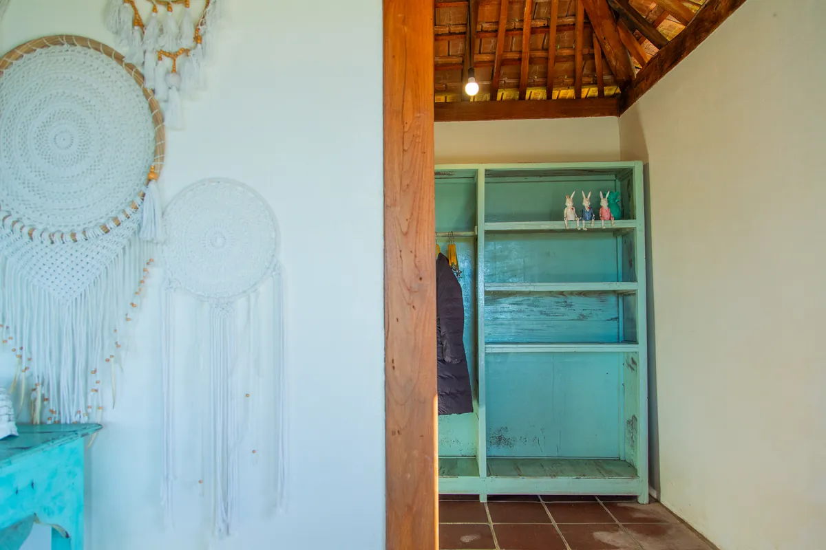 A turquoise cabinet against lime wash