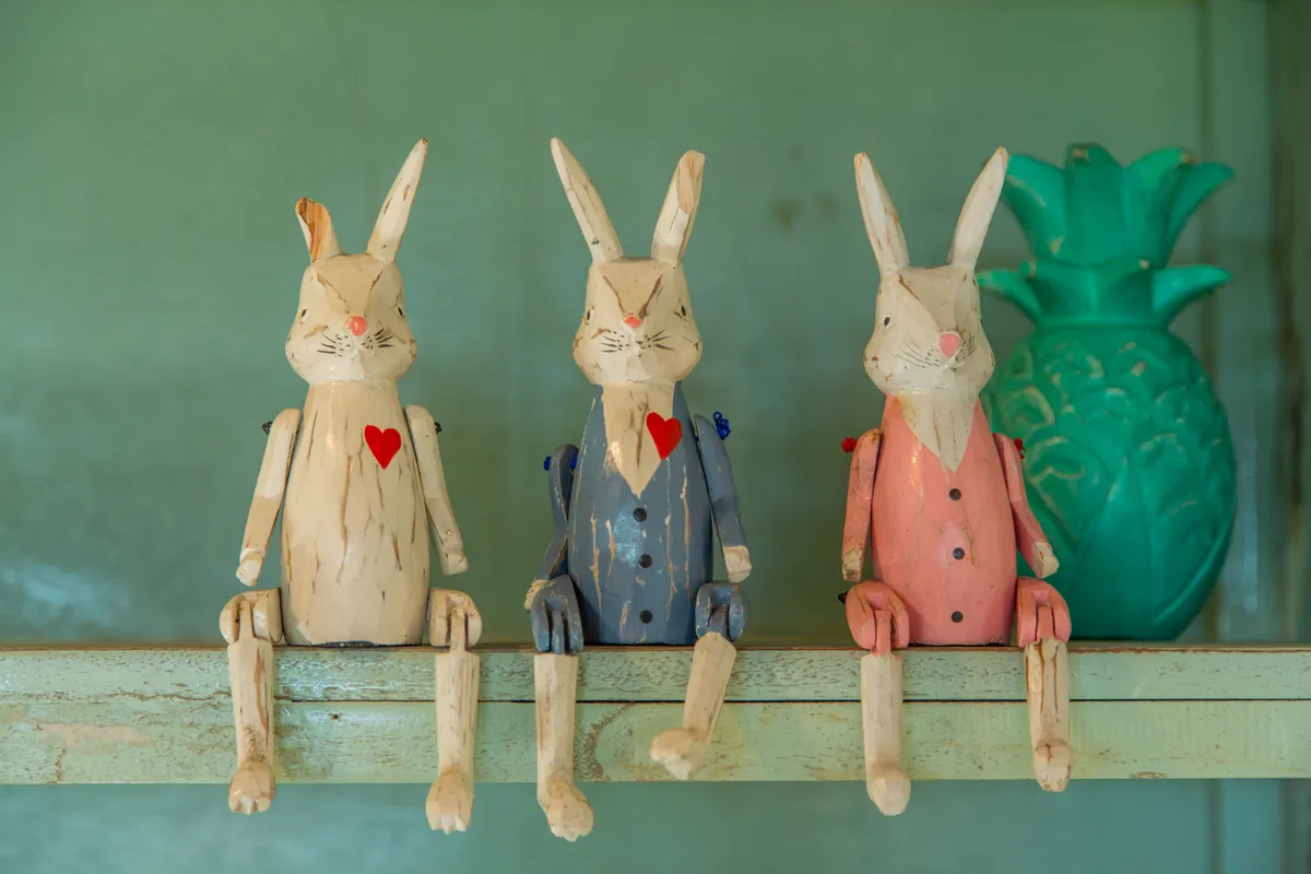 Carved wooden figures on a painted shelf
