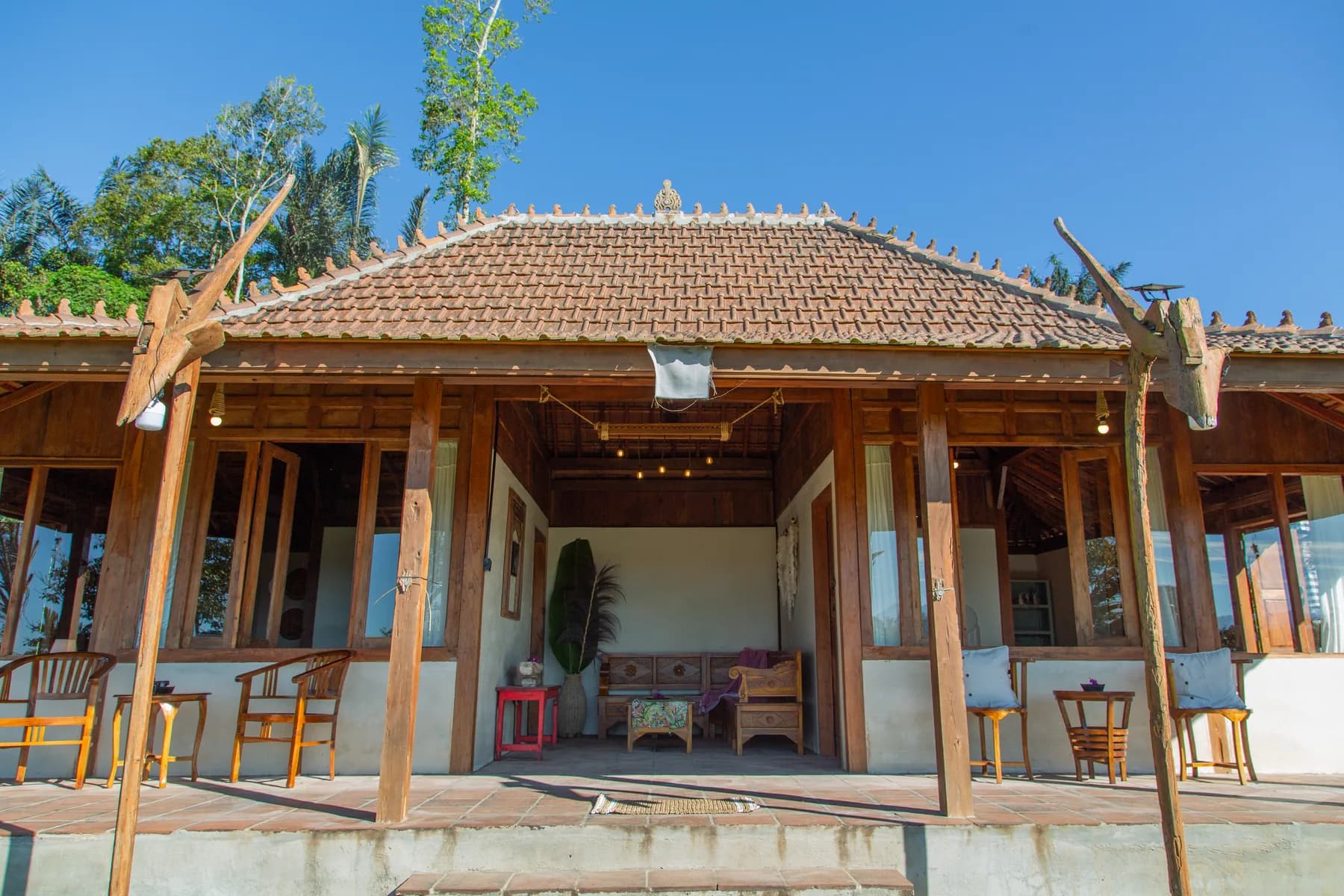The open wooden front of the house at The Hut under a clear Kintamani sky
