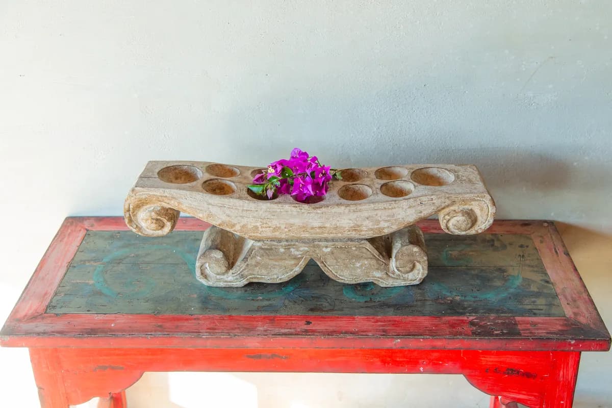 Fresh bougainvillea laid on a carved stone table, a daily Balinese Hindu offering