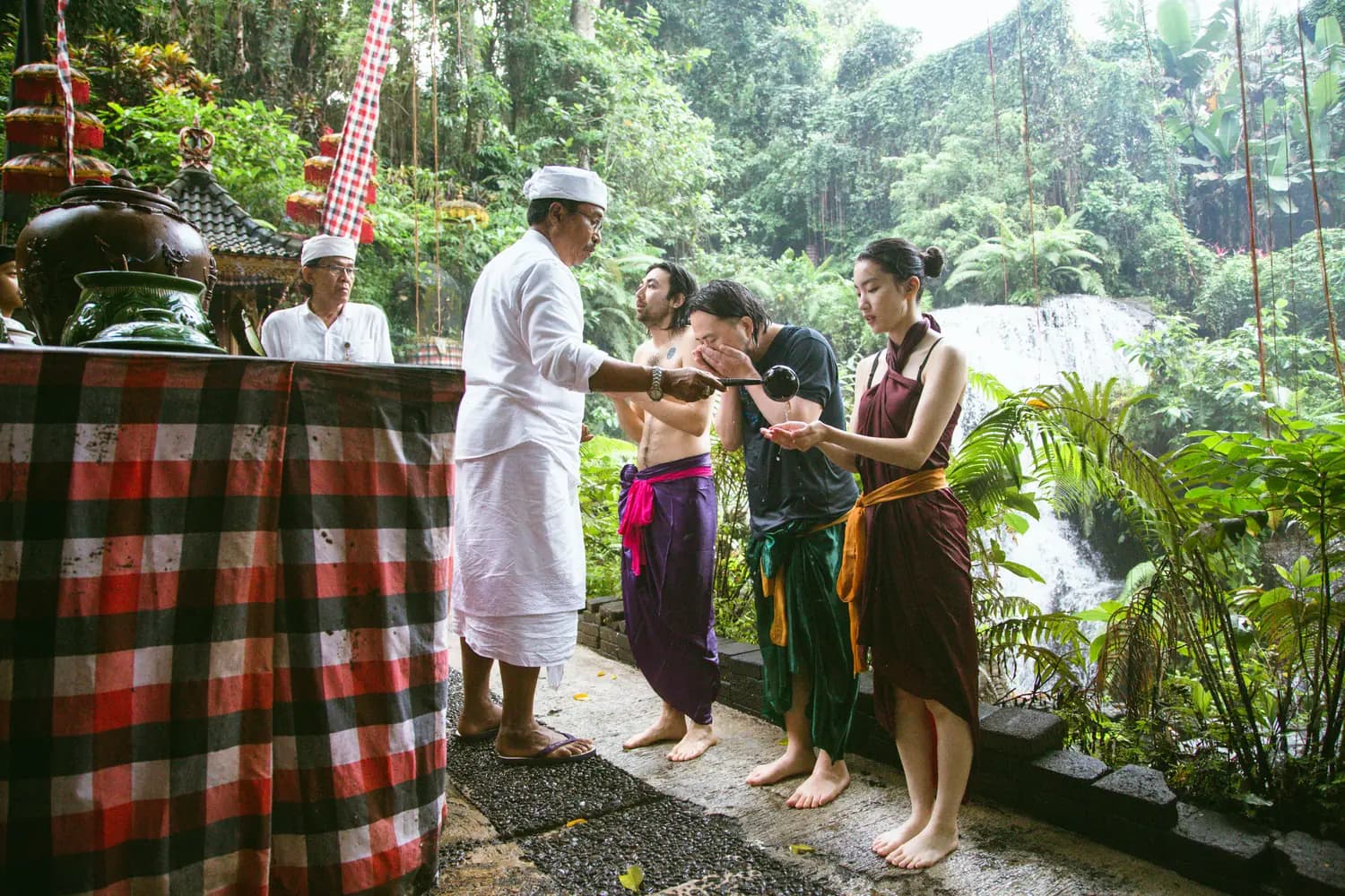 Visitors in sarongs waiting in line at the temple gate to be blessed