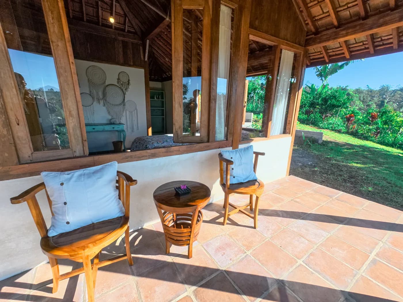 Chairs and a low table on the tiled veranda, looking out over the highland