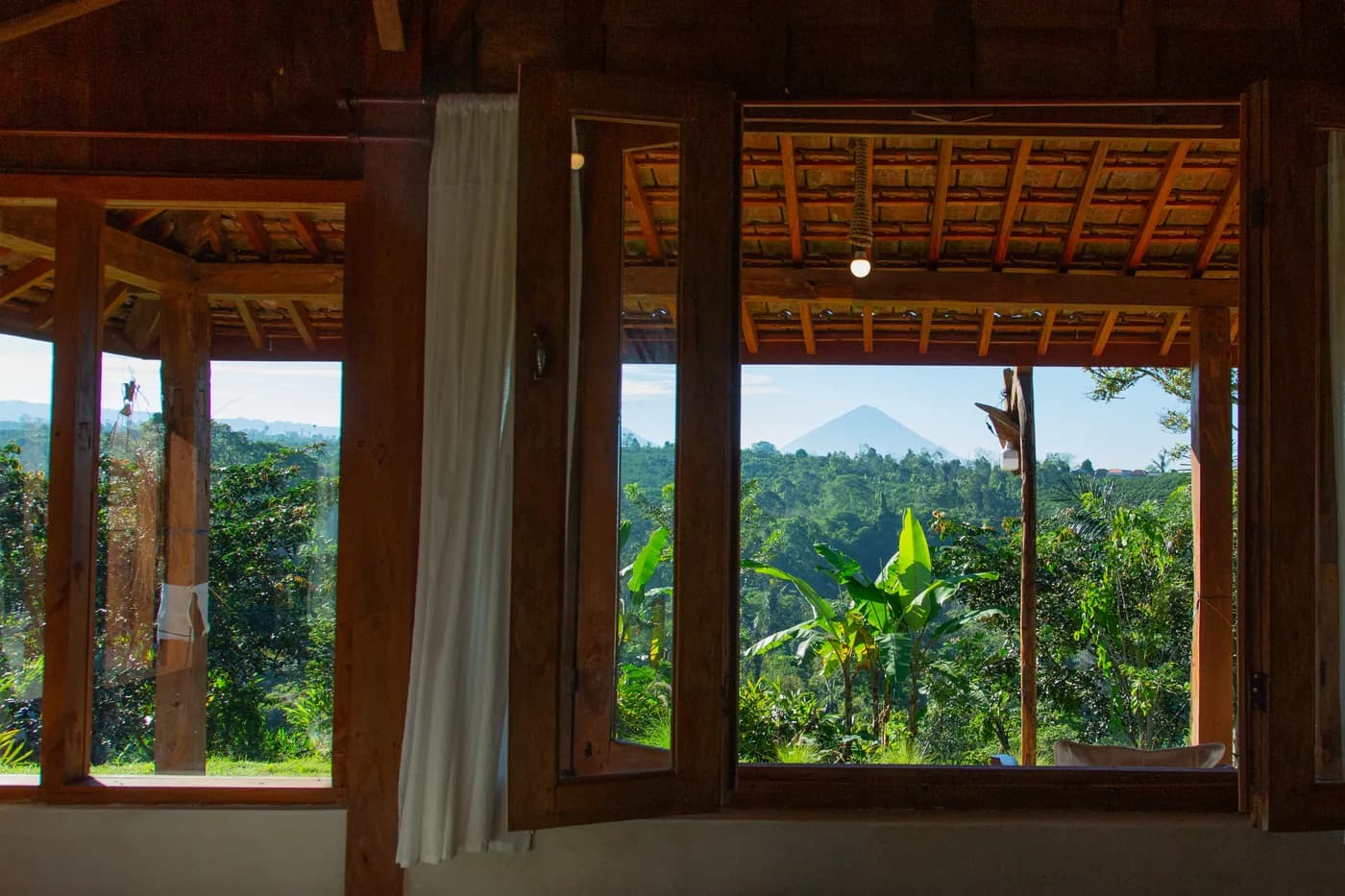 The valley framed by the tall timber windows of the house